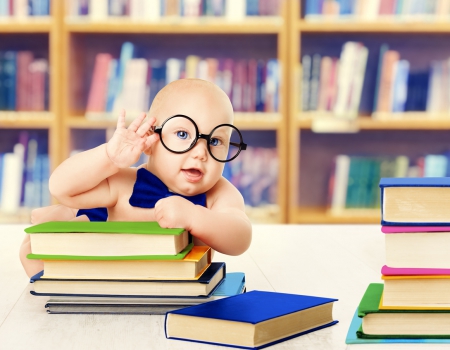 bébé avec pile de livres et des lunettes rondes sur le visage